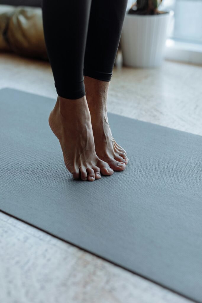 A serene moment capturing feet in a yoga pose on a mat in a bright room.
